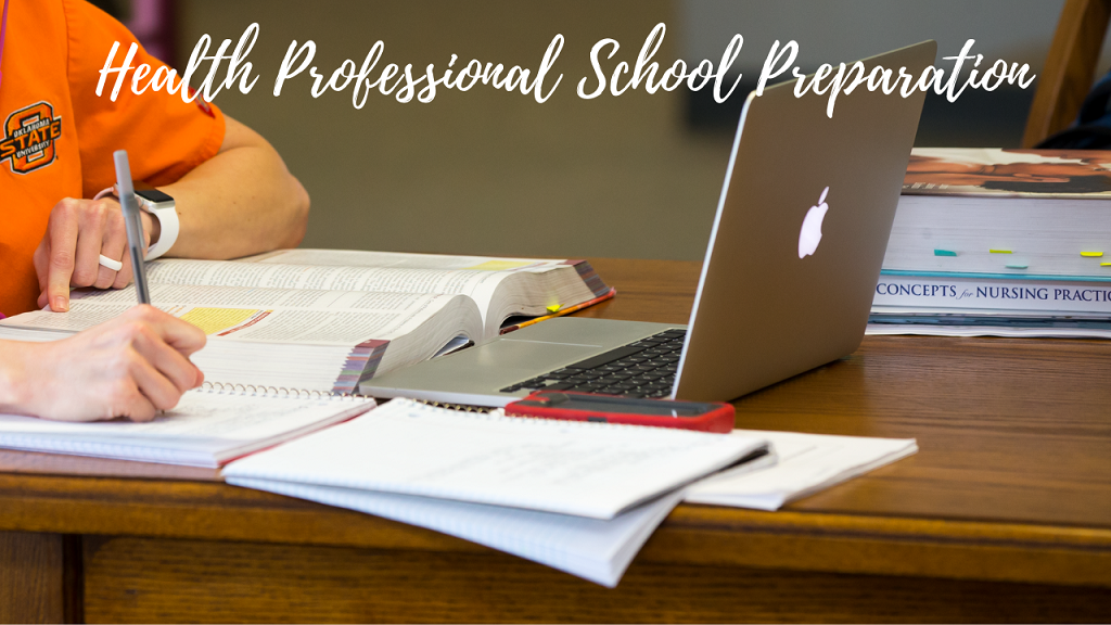 close up of a student wearing orange scrubs sitting before an open laptop taking notes on a piece of paper while nursing books sit on the corner of the table