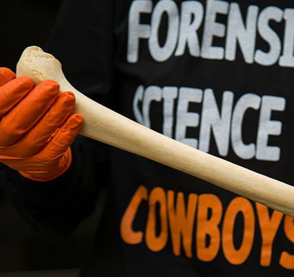pre-reqs.png Student wearng a Forensice Science Cowboys holds a bone.
